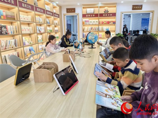 阿依丁库勒村图书馆内，孩子们正在阅读。人民网记者 陈新辉摄