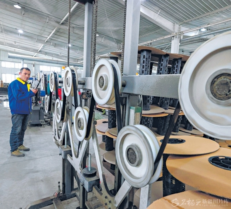 3月17日，精河县兴晟塑业有限公司工人在车间生产滴灌带。该公司正开足马力加紧生产，保障春耕。（摄影：于苏甫·艾尼）